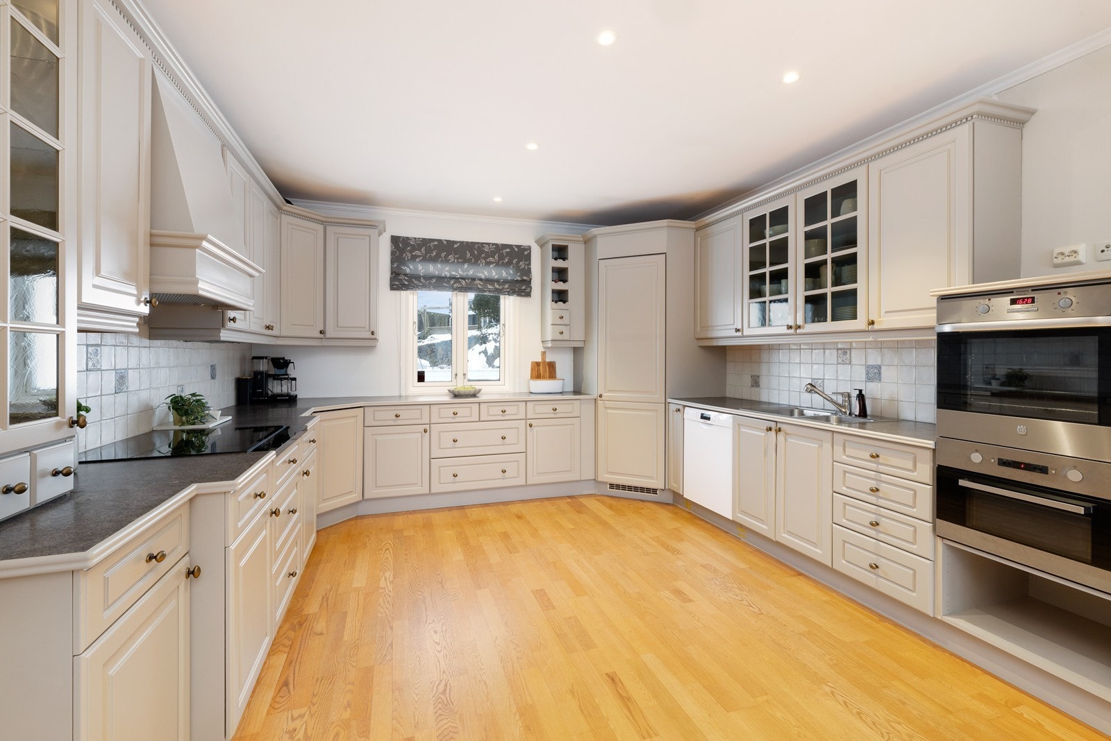 Stort kjøkken med mye skap- og benkeplass Galleribilde