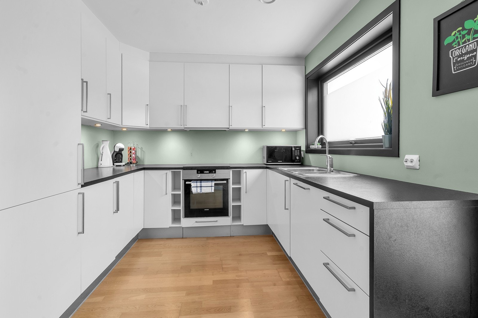 Kjøkken med mye skap- og benkeplass. Kjøkkenet er utstyrt med integrerte hvitevarer. Galleribilde