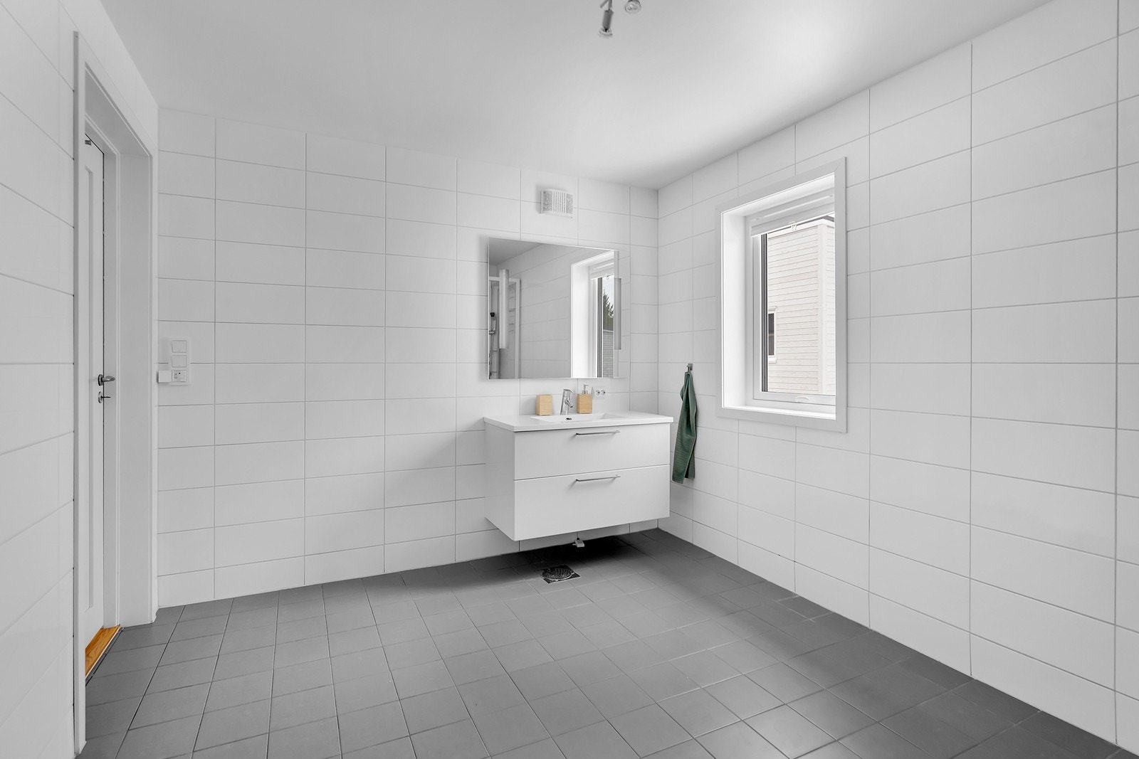 Bad 2.etg med flis på gulv og vegg, varme i gulv, dusjkabinett, vegghengt toalett og servant med underskap. Galleribilde