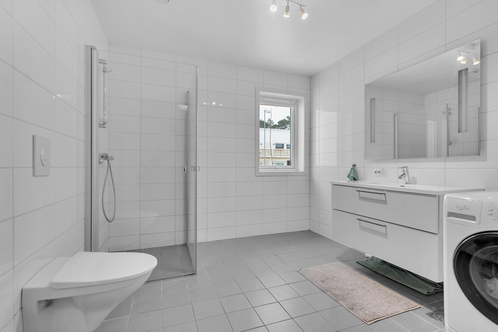 Bad 1.etg utstyrt med varme i gulv, vegghengt toalett, dusjnisje med glassdører, opplegg for vaskemaskin og servant med underskap. Galleribilde