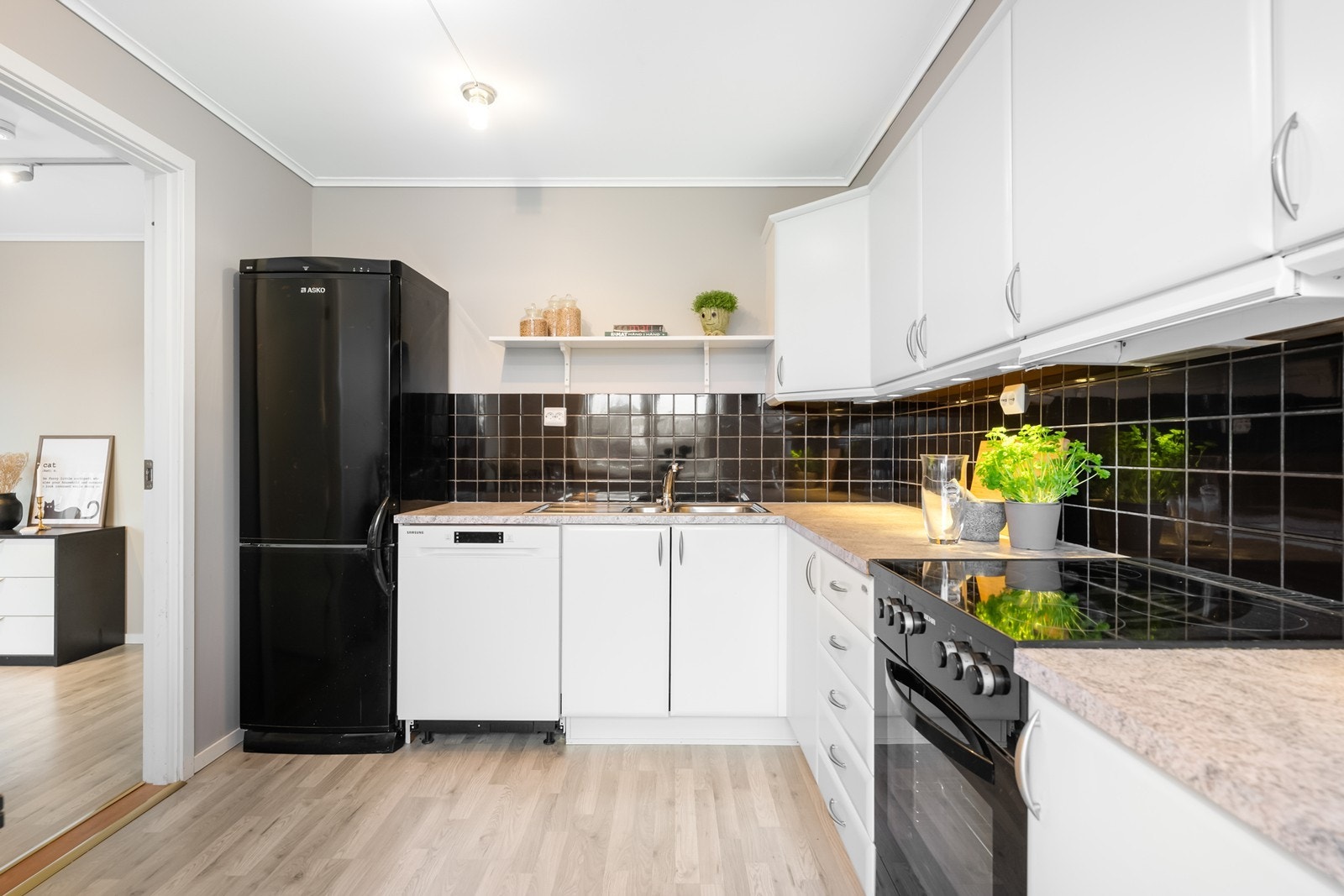 Lyst og pent kjøkken med god skap- og benkeplass Galleribilde