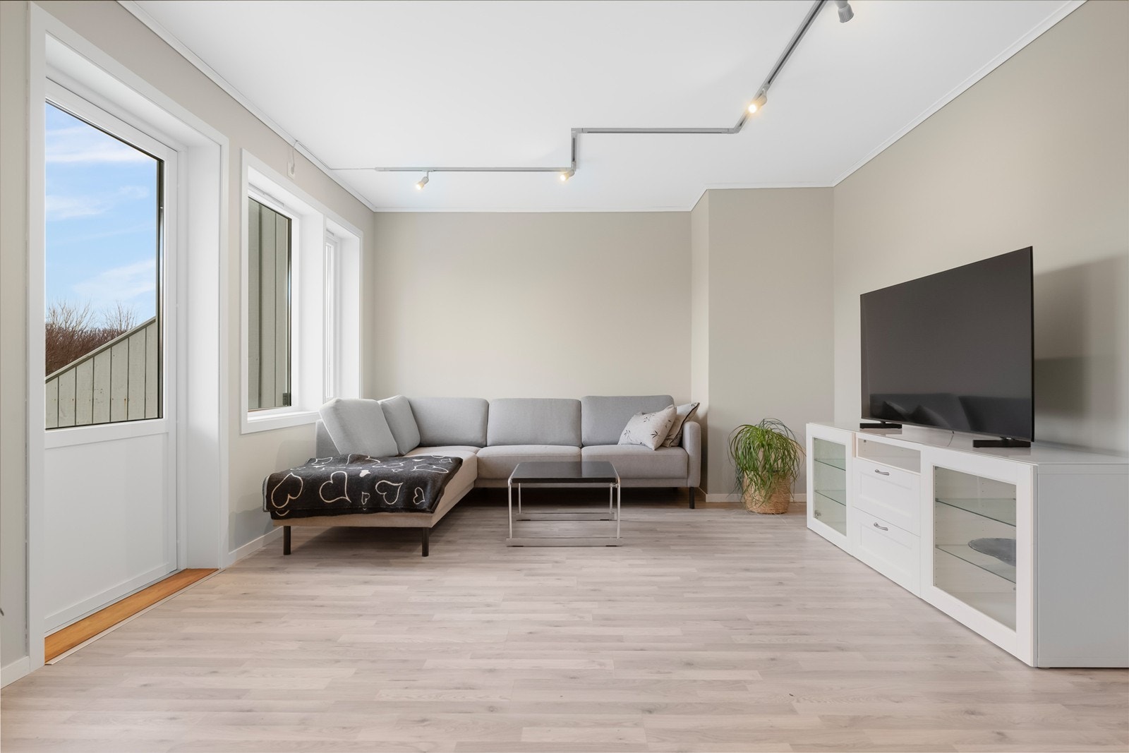 Stue med laminat gulv og malte slette vegger Galleribilde