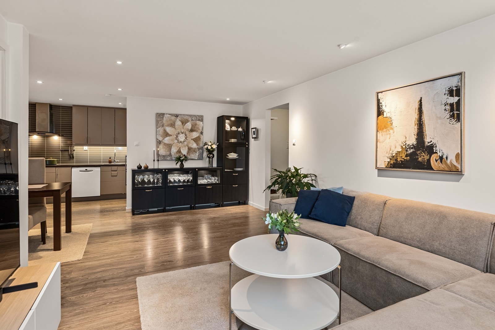 Fra entreen åpner leiligheten seg opp mot stue og kjøkken i en sosial, åpen løsning. Galleribilde