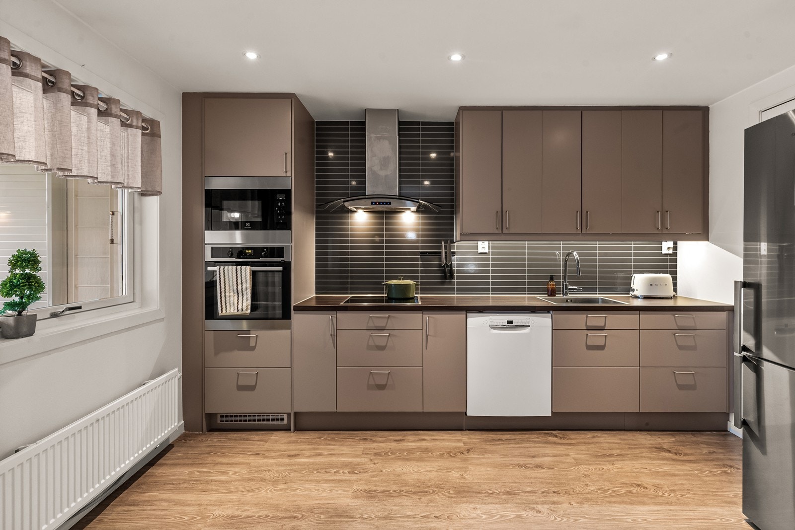 Stilrent kjøkken med god skap- og benkeplass, samt integrerte hvitevarer. Galleribilde