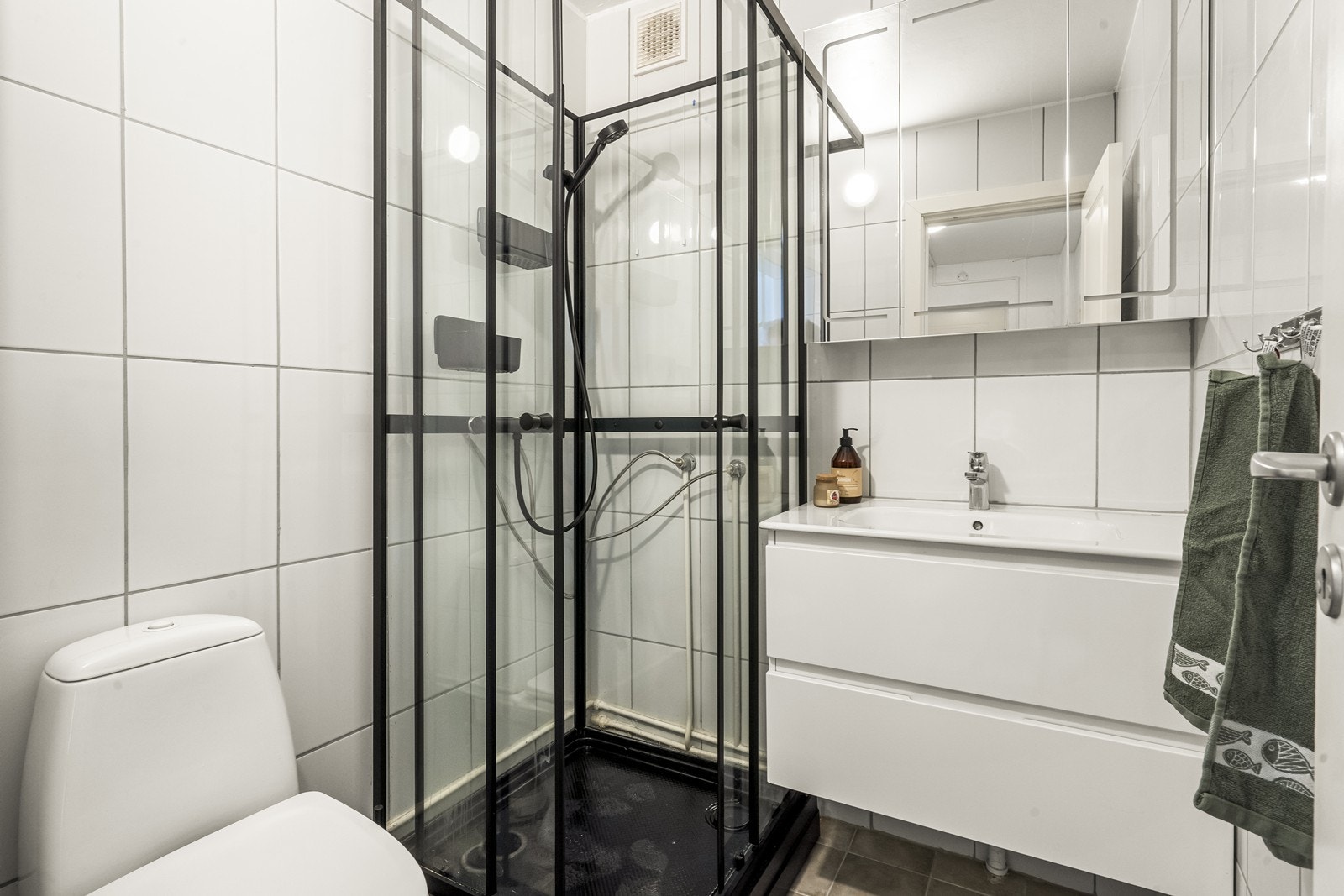 Her er det også en stilren servantinnredning med skuffer og speilskap for oppbevaring Galleribilde