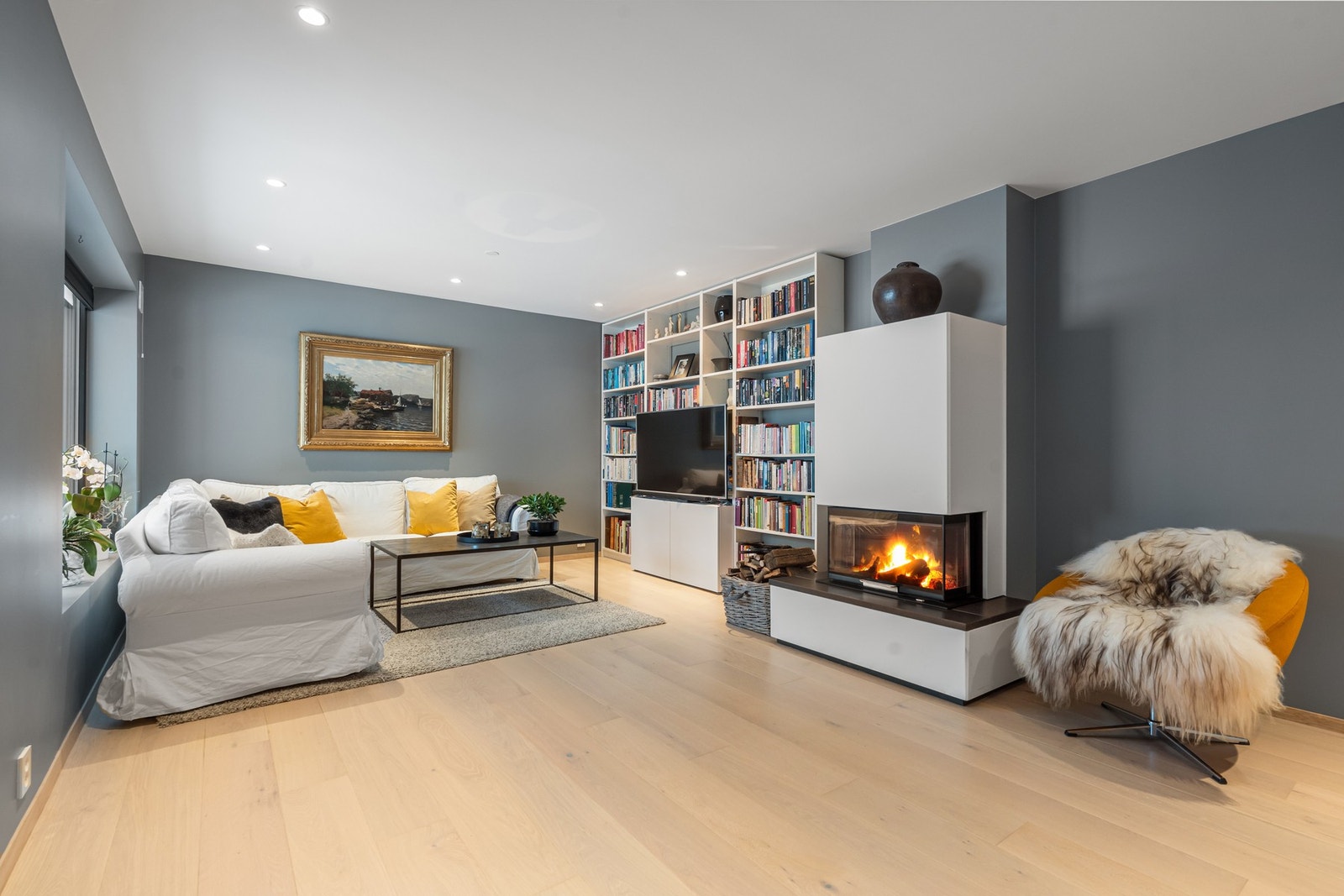 Kjellerstuen er romslig og fleksibel i bruk, med god plass til både sofagruppe, mediemøbler og bokhyller. Galleribilde