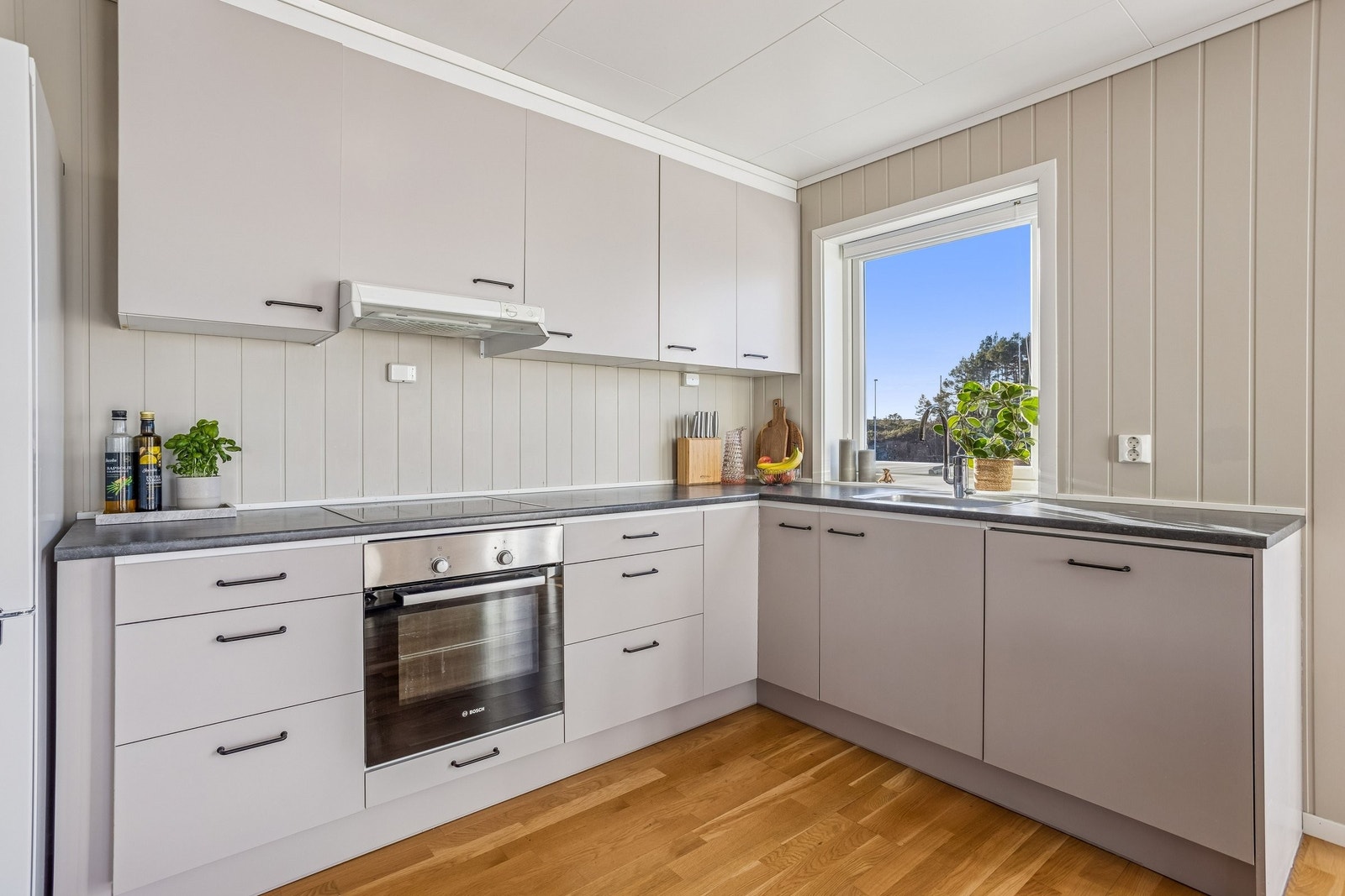 Fint vinkelformet kjøkken med god skap- og benkeplass. Galleribilde