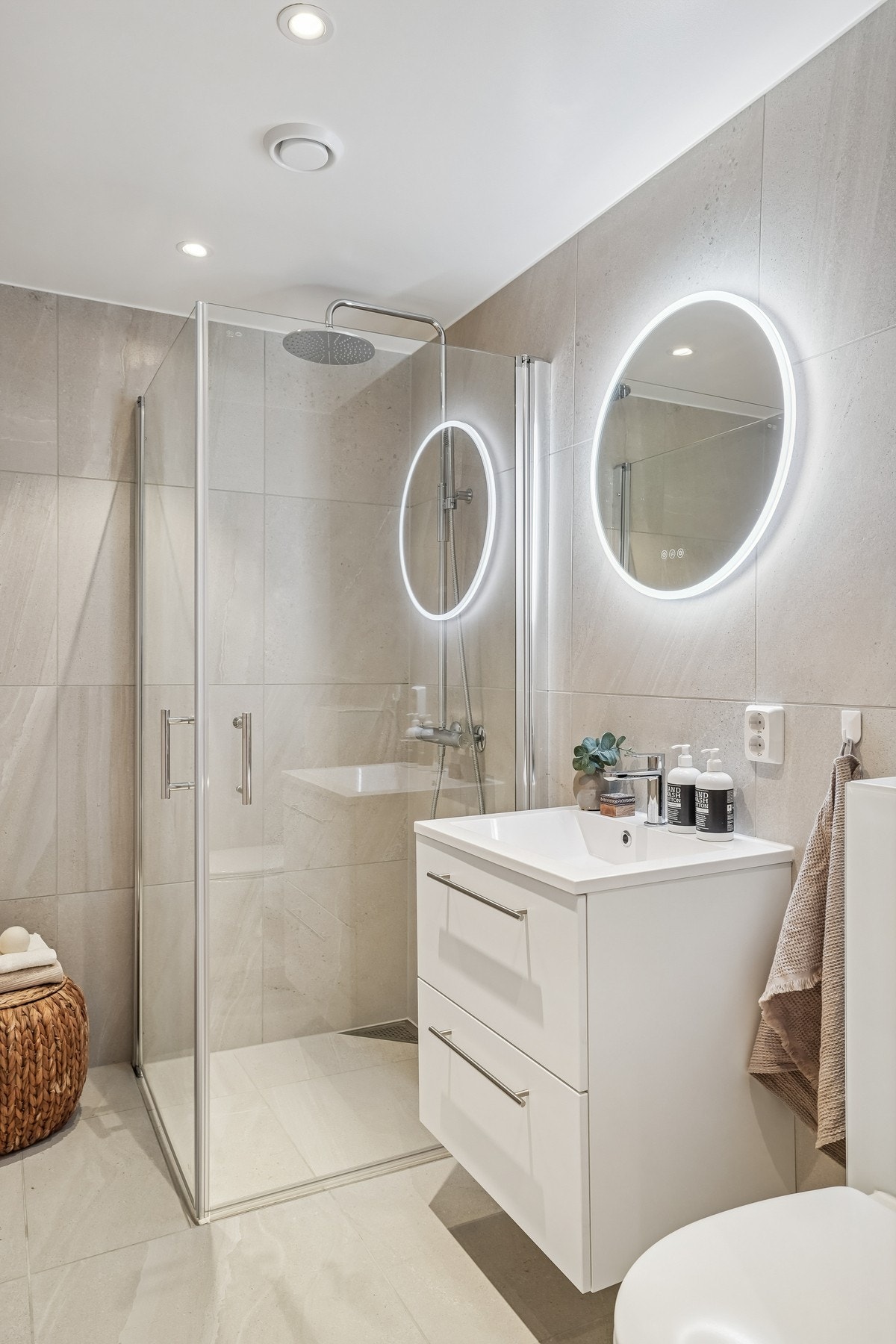 - og servantinnredning med skuffefronter, heldekkende servant og overliggende speil med integrert belysning. Galleribilde