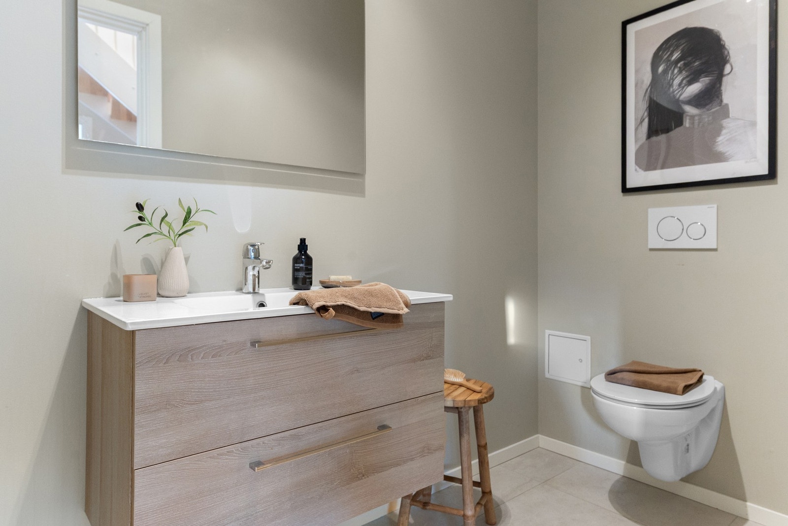 Pent toalettrom med vegghengt toalett og servant med innredning. Galleribilde