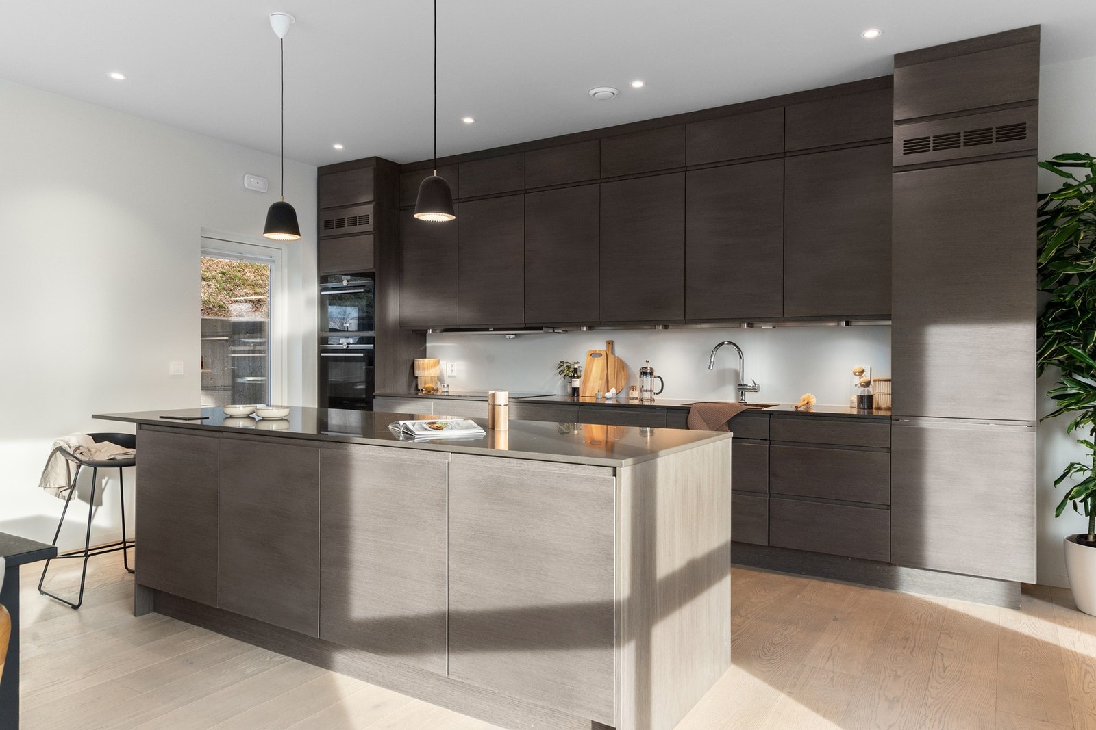 Kjøkkenet har slette fronter og steinkompositt benkeplate. Galleribilde