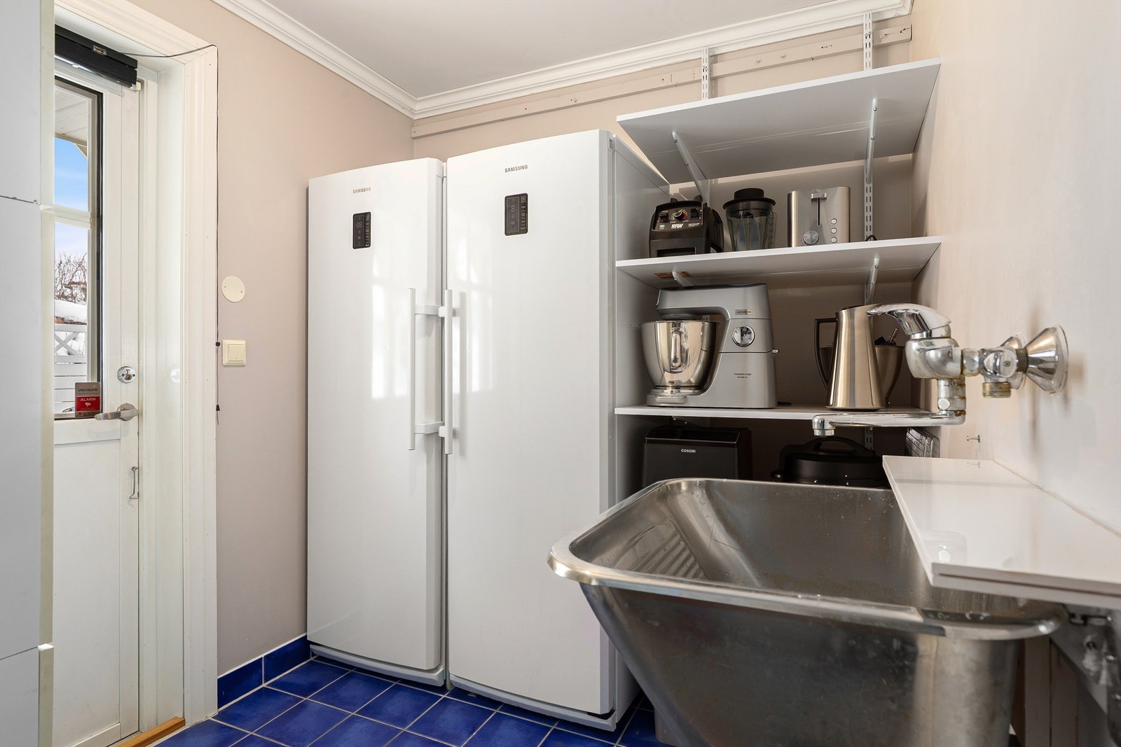 Et praktisk grovkjøkken/vaskerom med utgang til hage Galleribilde