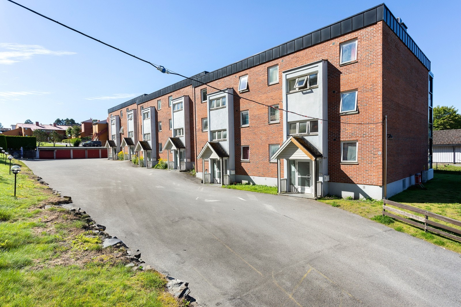 Felles biloppstillingsplass ved inngangspartiene til blokken. Det er mulighet for lading av elbil. Galleribilde