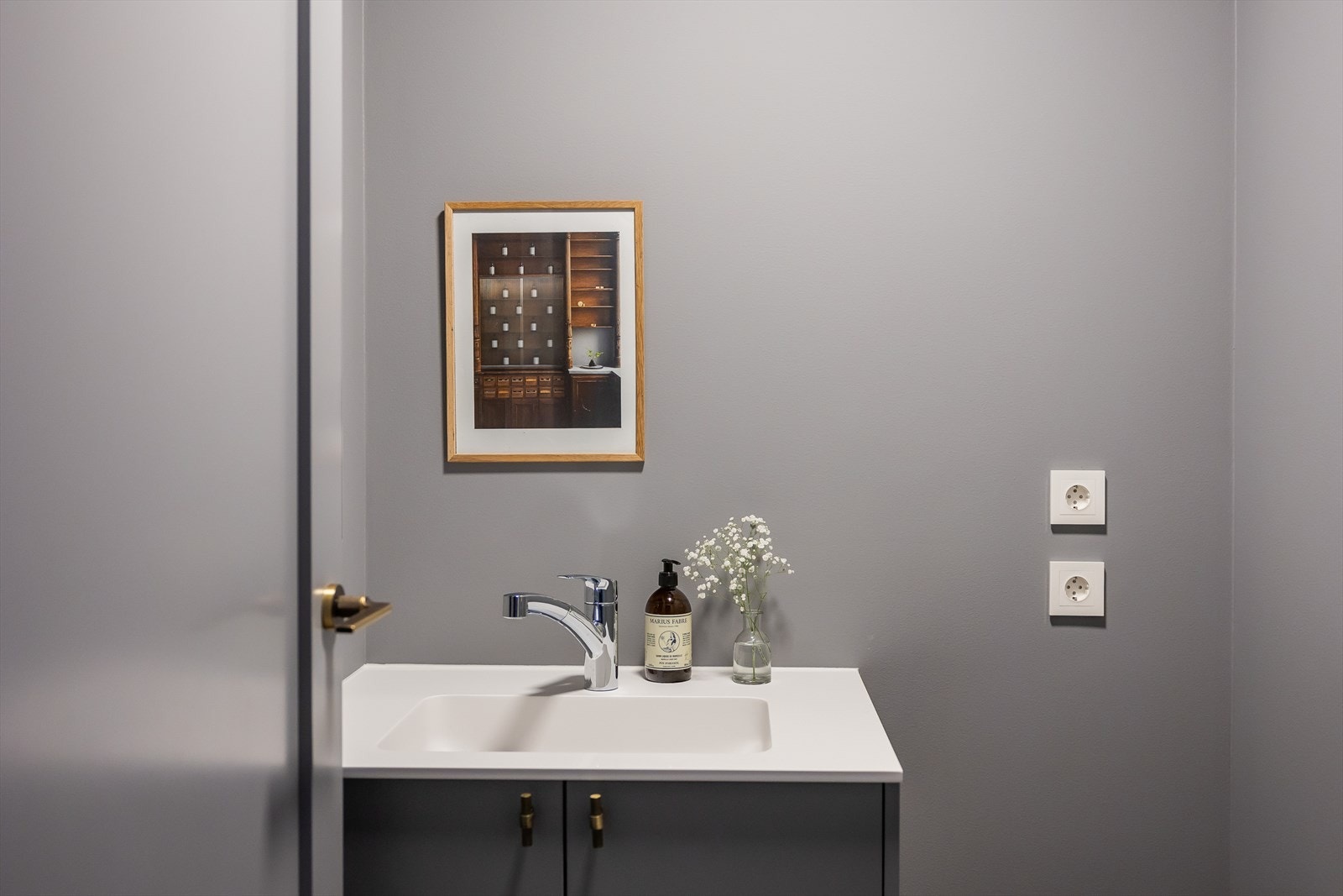 Separat vaskerom med Terazzoflis på gulv, vegghengt servant og uttak for vaskemaskin Galleribilde