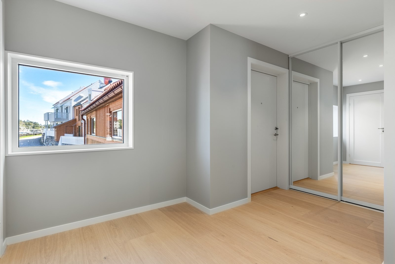 Stor og åpen gang med garderobeskap med speilfronter. Galleribilde