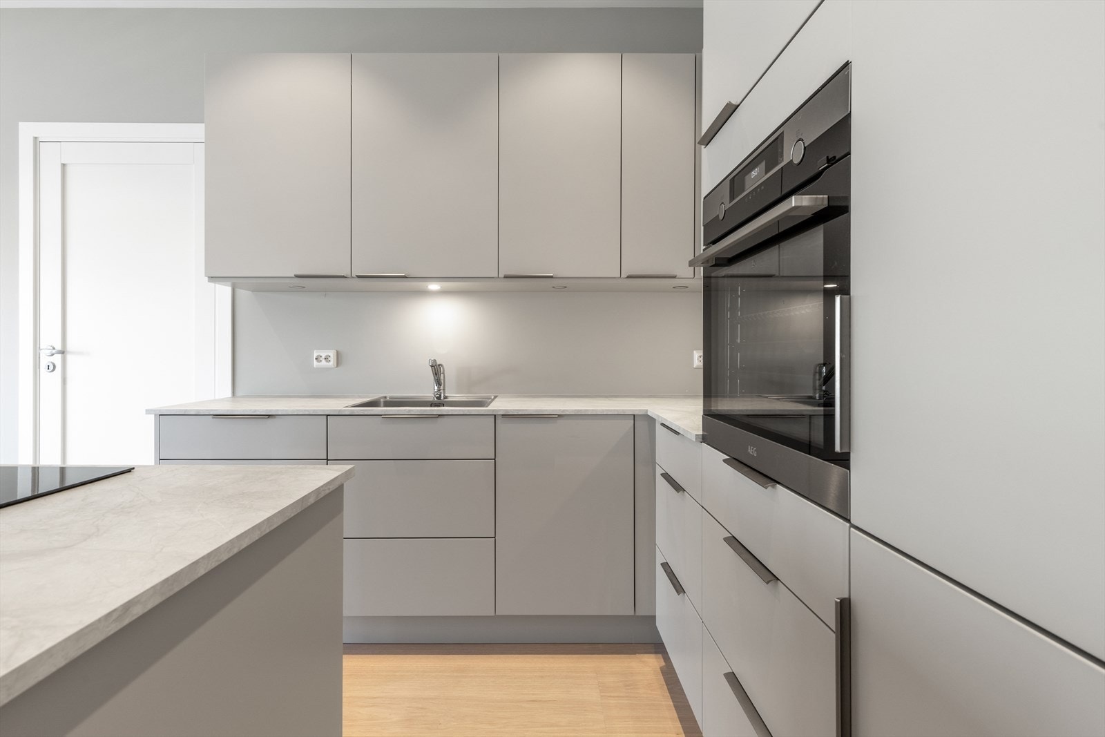 Kjøkken i moderne og stilren utførelse hvor alle hvitevarer er integrert. Galleribilde