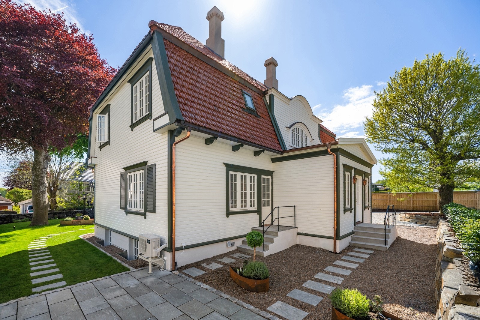 Over gressplenen er det lagt gangheller bort til en usjenert markterrasse, dekket av skiferheller, i hjørnet av hagen. Galleribilde