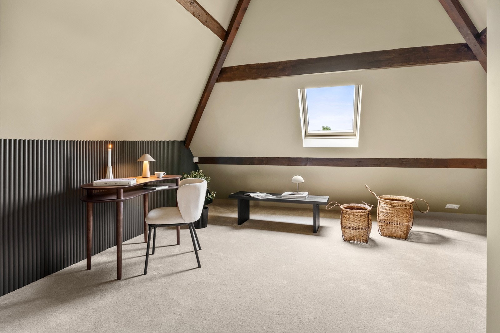 Loftstuen er langstrakt og koselig, delt i tre soner med takvindu i siderommene og glassfasade med sort smijernsramme og glassdør mot trapperommet, som lar dagslyset slippe inn. Galleribilde