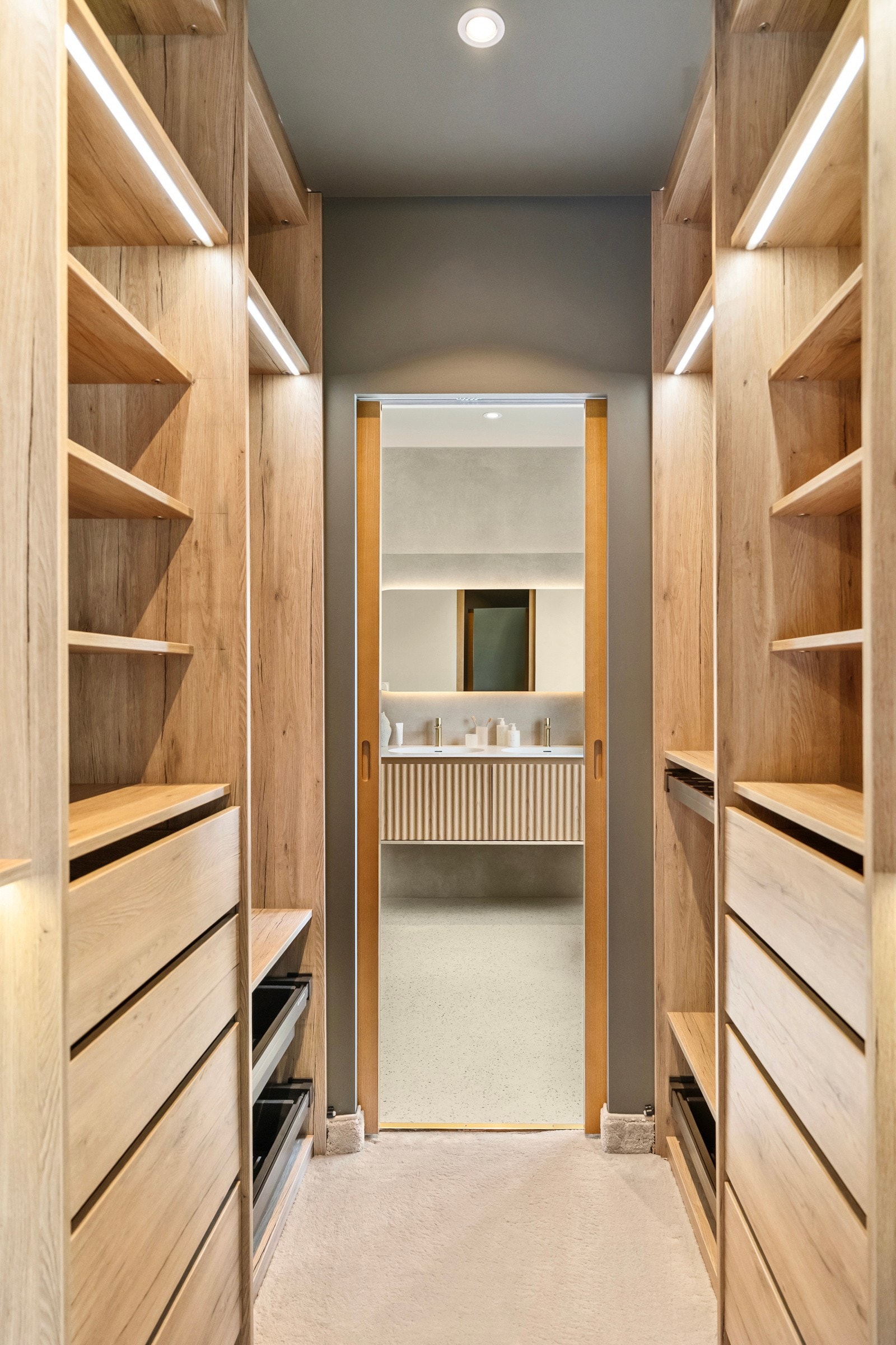 Garderoberommet i hovedsuiten er innredet med plassbygde, åpne eikeskap, som har ledbelysning, hyller, skuffer og skohyller parallelt langs to sider. Galleribilde