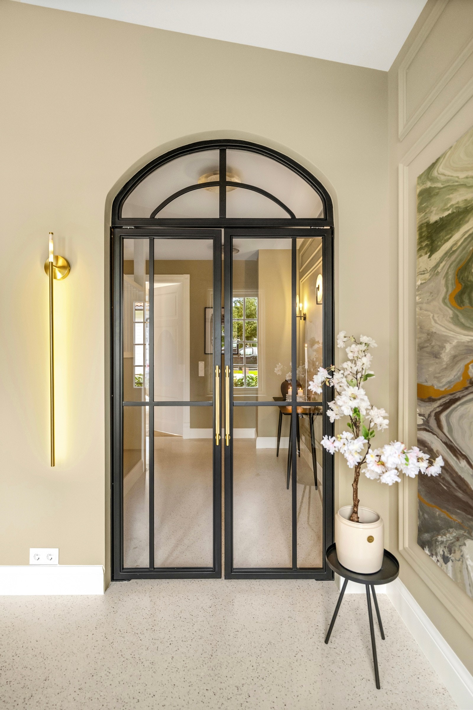 En pen, ny trapp leder ned til kjelleren, og en tofløyet buedør i glass med smijernsramme fører inn til hallen. Galleribilde