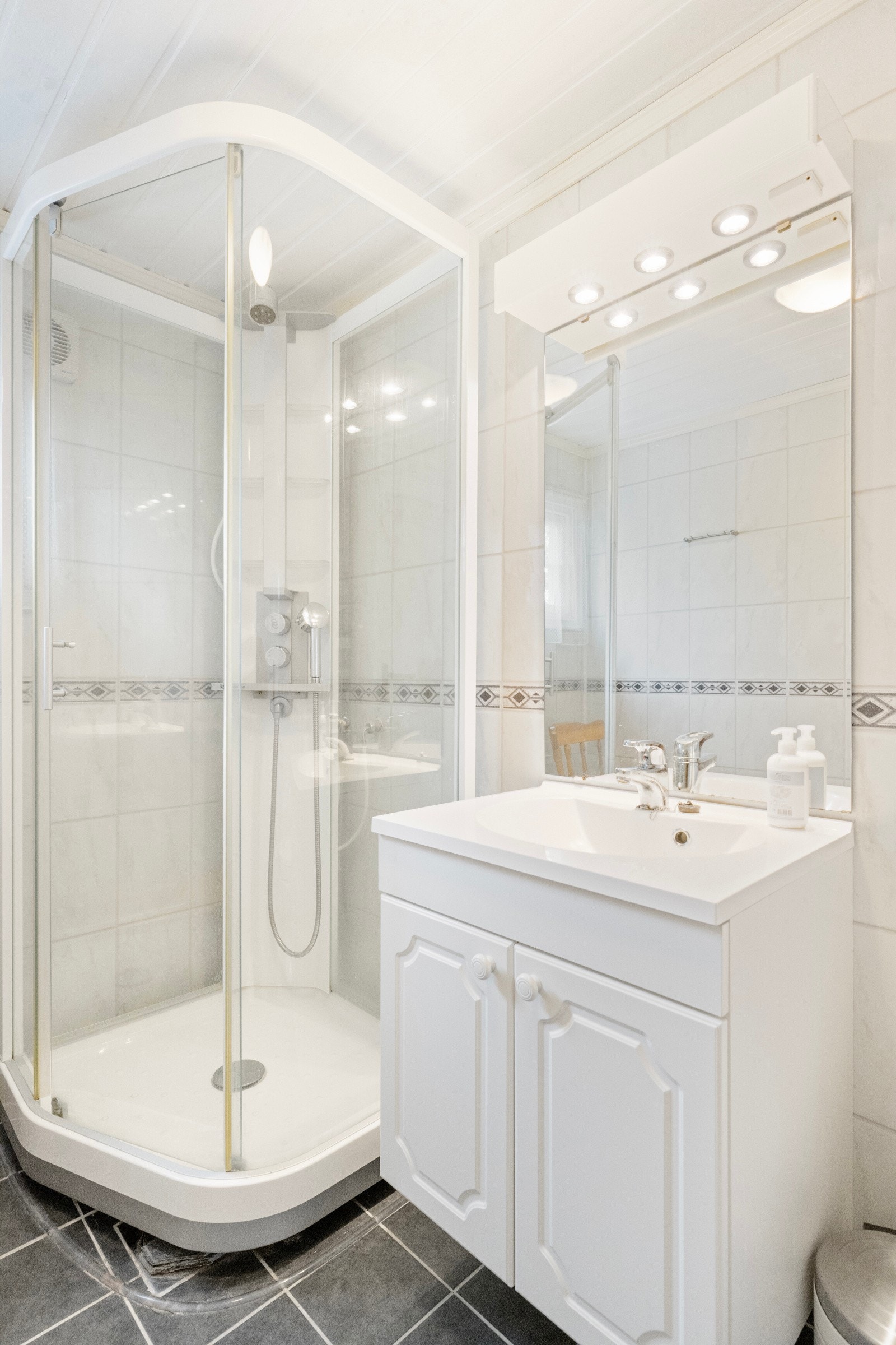 Badet er innredet med servant med skap, WC og dusjkabinett Galleribilde