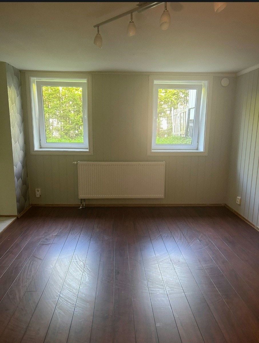 Stue med rikelig sollys og stor radiator Galleribilde