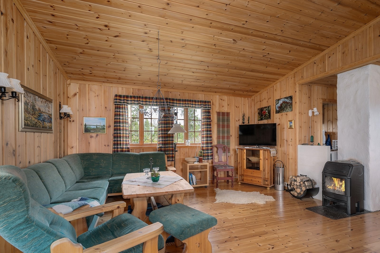 Peisovnen er plassert sentralt i rommet som gir ekstra god varme. I tillegg varmes hytta opp med elektrisk fyring. Galleribilde