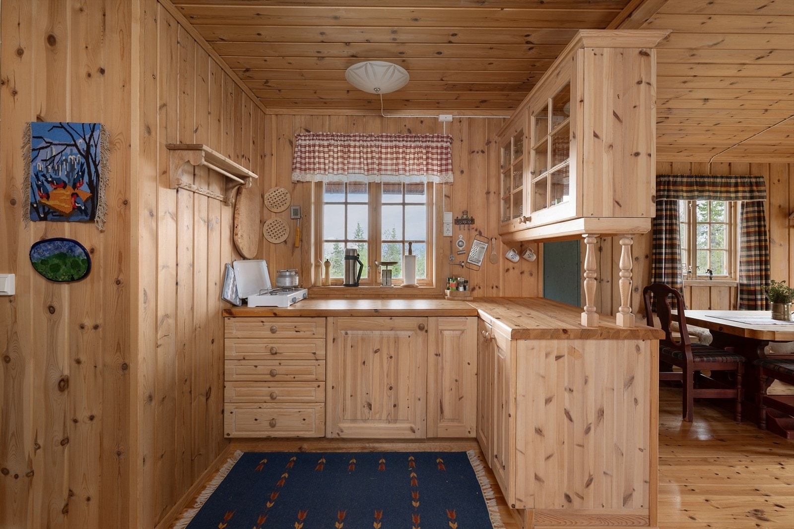 Heltre innredning på kjøkkenet med over-og underskap. Fint lys inn over kjøkkenbenken. Galleribilde