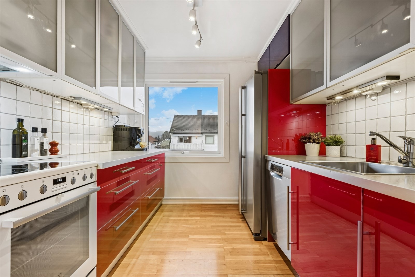 Kjøkken med side by side kjøleskap, komfyr og oppvaskmaskin. Galleribilde