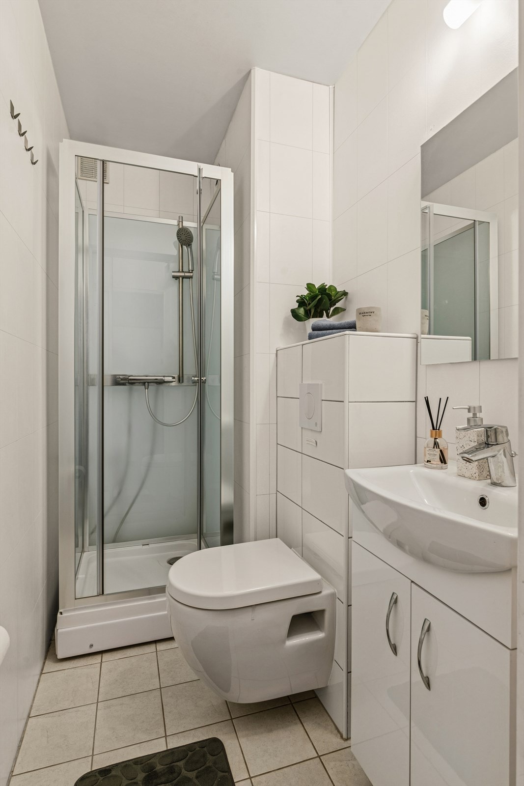 Dusjbad/gjestetoalett med adkomst fra entréen. Oppgradert med vegghengt toalett og servant med skap. Galleribilde