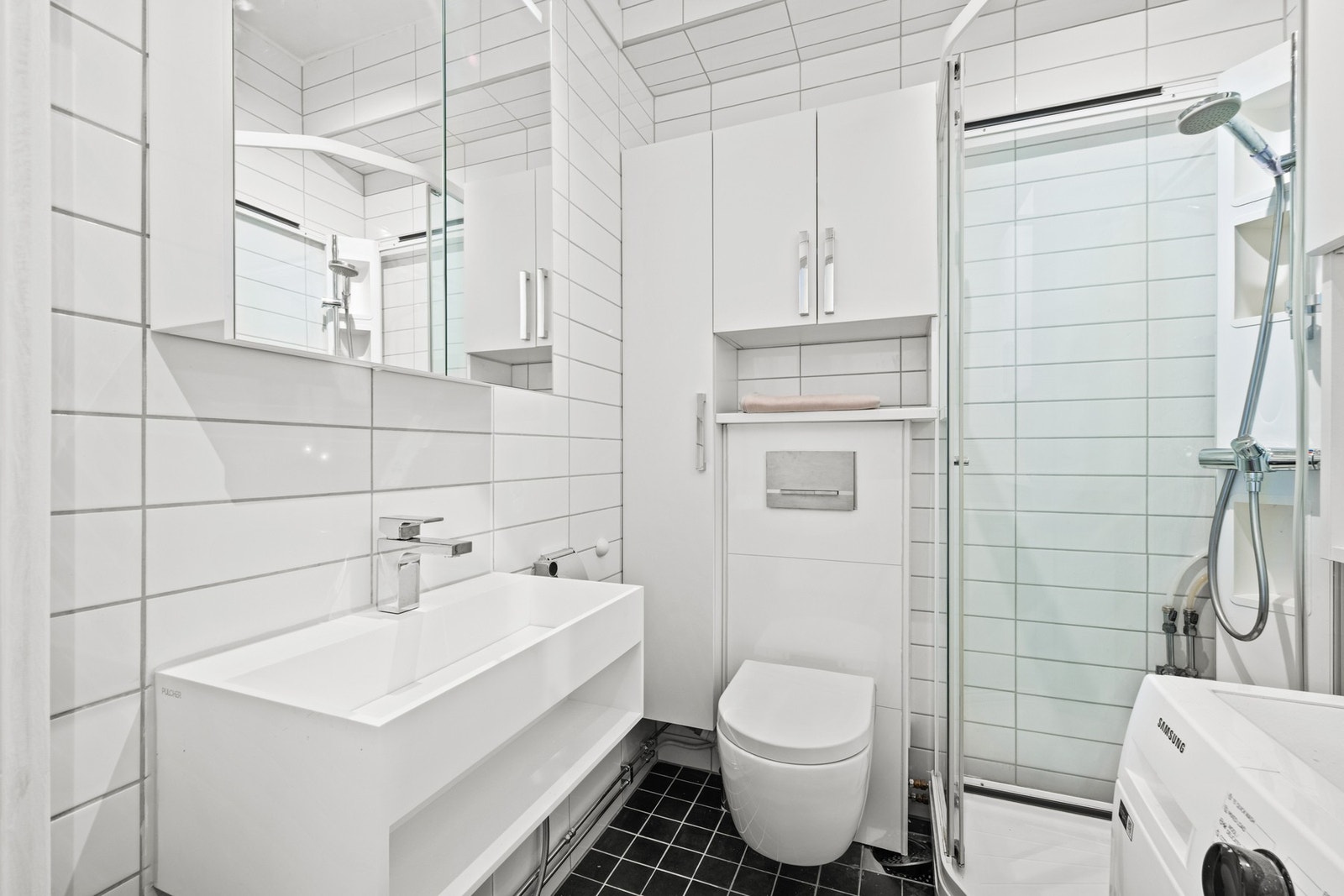 Badet er flislagt og fremstår som tidløst og praktisk. Galleribilde