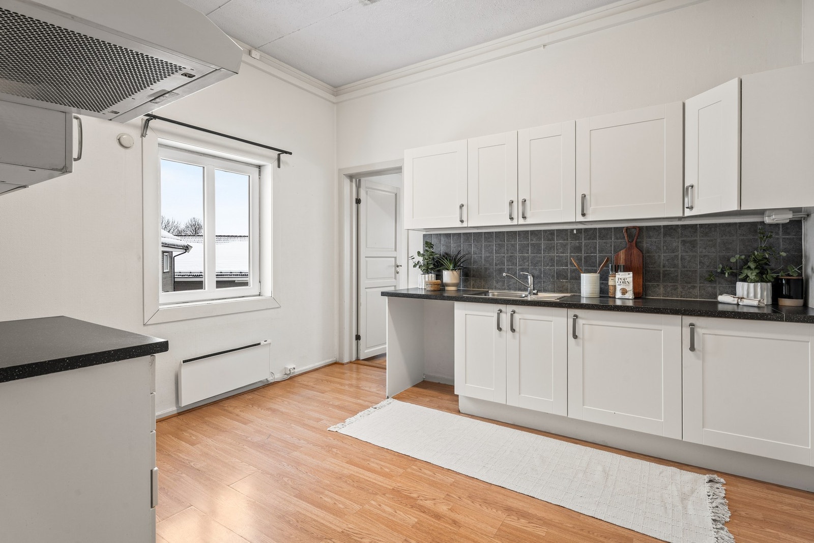 Benkeplaten er i mørk laminat. Det er opplegg for oppvaskmaskin samt plass til komfyr og kjøl/frys Galleribilde