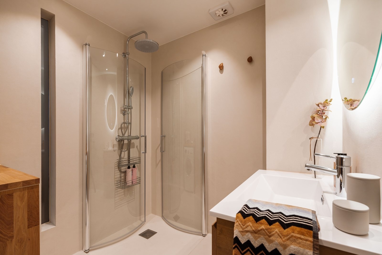 Innfellbare glassdører og regnfallsdusj gir dusjhjørnet både funksjonalitet og eleganse. Galleribilde