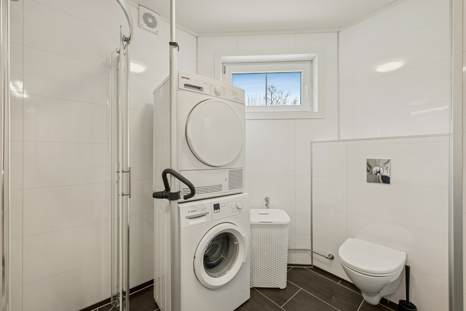 Badet har vegghengt toalett, opplegg for vaskemaskin, dusjhjørne og god skapinnrednig. Galleribilde