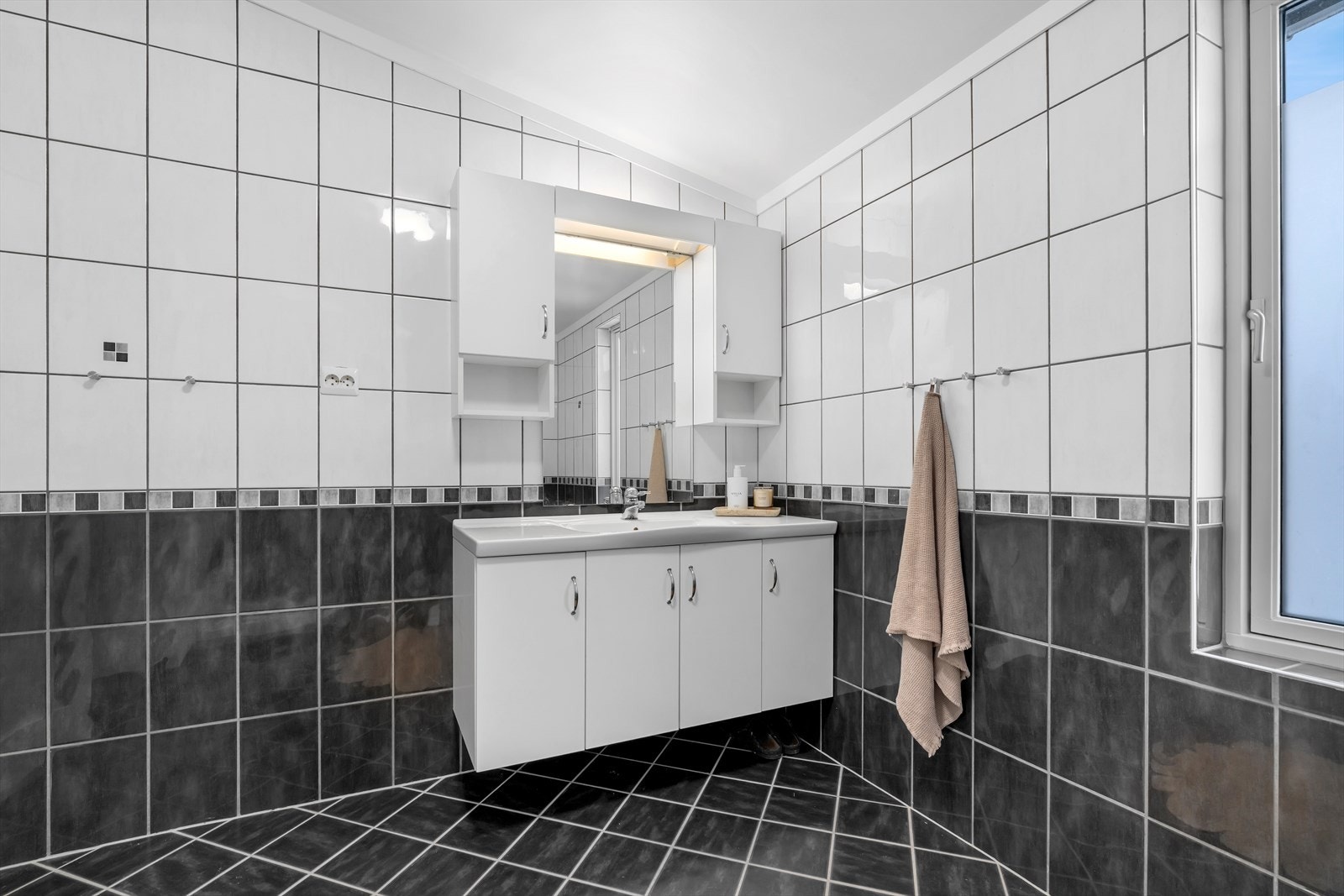 Badet inneholder dusjkabinett, toalett og en romslig innredning med god plass til oppbevaring. Galleribilde