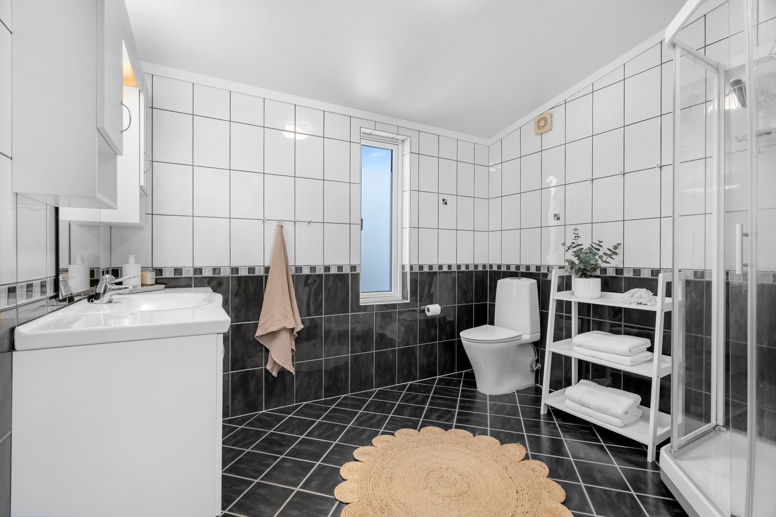 Bad i 2. etasje: Et svært romslig og gjennomført baderom med fliser både på gulv og vegger, som gir et lekkert og tidløst preg. Gulvvarme sørger for ekstra komfort. Galleribilde