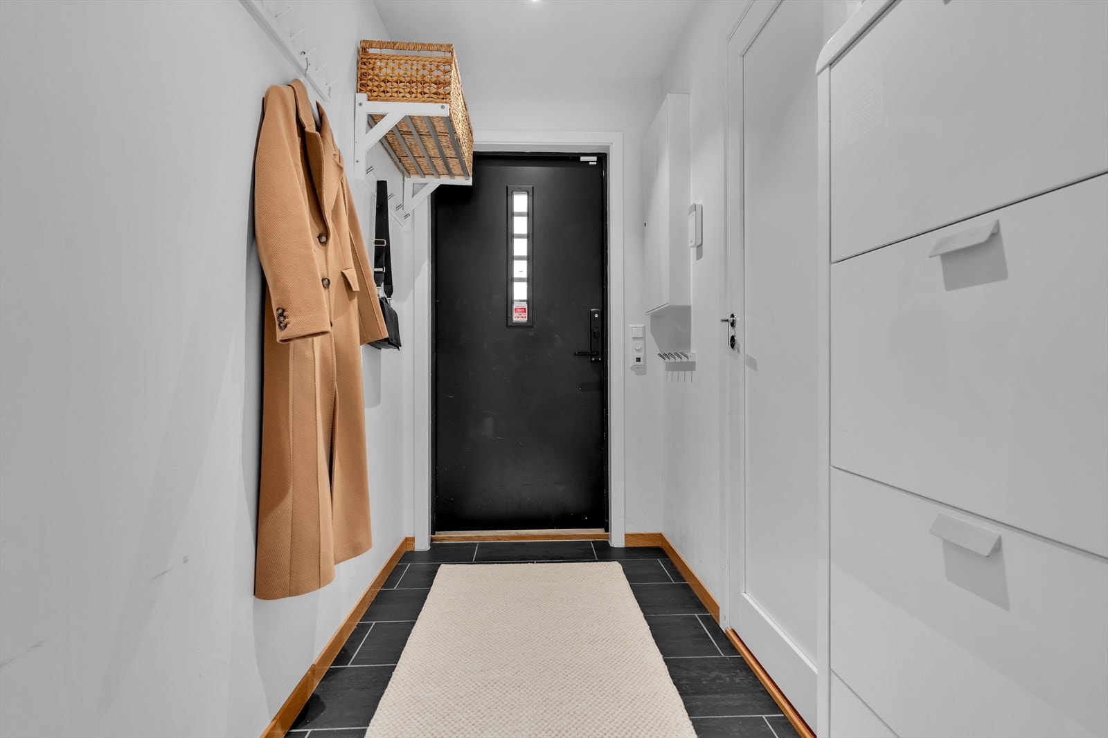 Når du trer inn i boligen, ønskes du velkommen av en romslig entré. Gulvet er belagt med fliser og har varmekabler. Det er godt med plass til oppheng av klær og sko, noe som gjør det enkelt å holde orden i hverdagen. Galleribilde