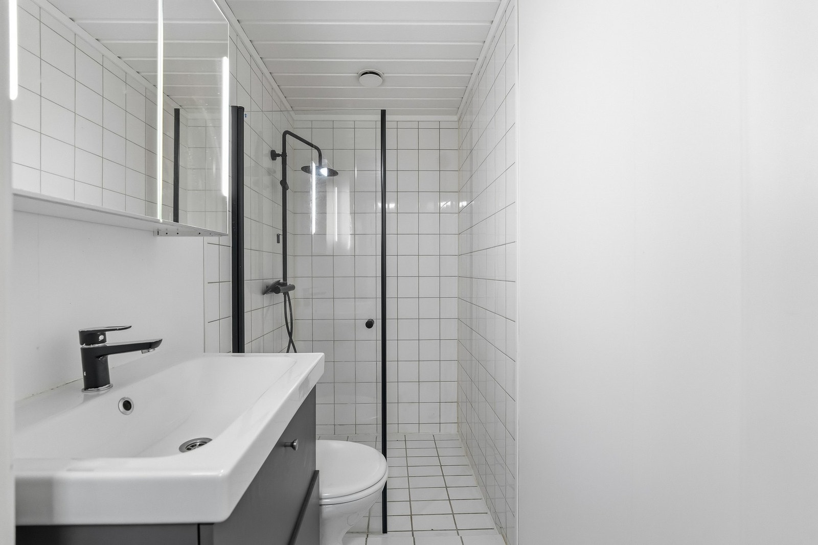 Badet har flislagt gulv med gulvvarme, fliser på vegger i våtsone og våtromsplater på øvrige veggflater. Galleribilde