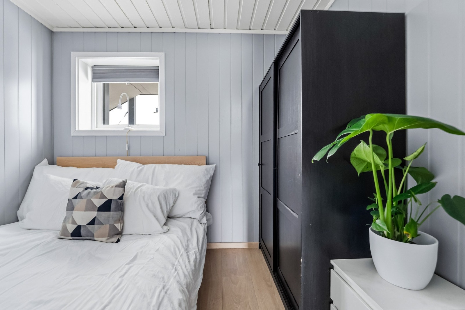 Rommet har malt smartpanel på veggflater, lyspigmentert laminatgulv, garderobeskap og stort vindu som gir godt lysinnslipp. Galleribilde