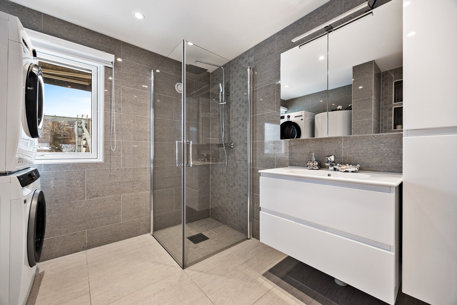 Her er det et romslig dusjhjørne og praktisk opplegg for vaskesøyle. Varmekabler i gulvet, samt dimbare downlights i himlingen. Galleribilde