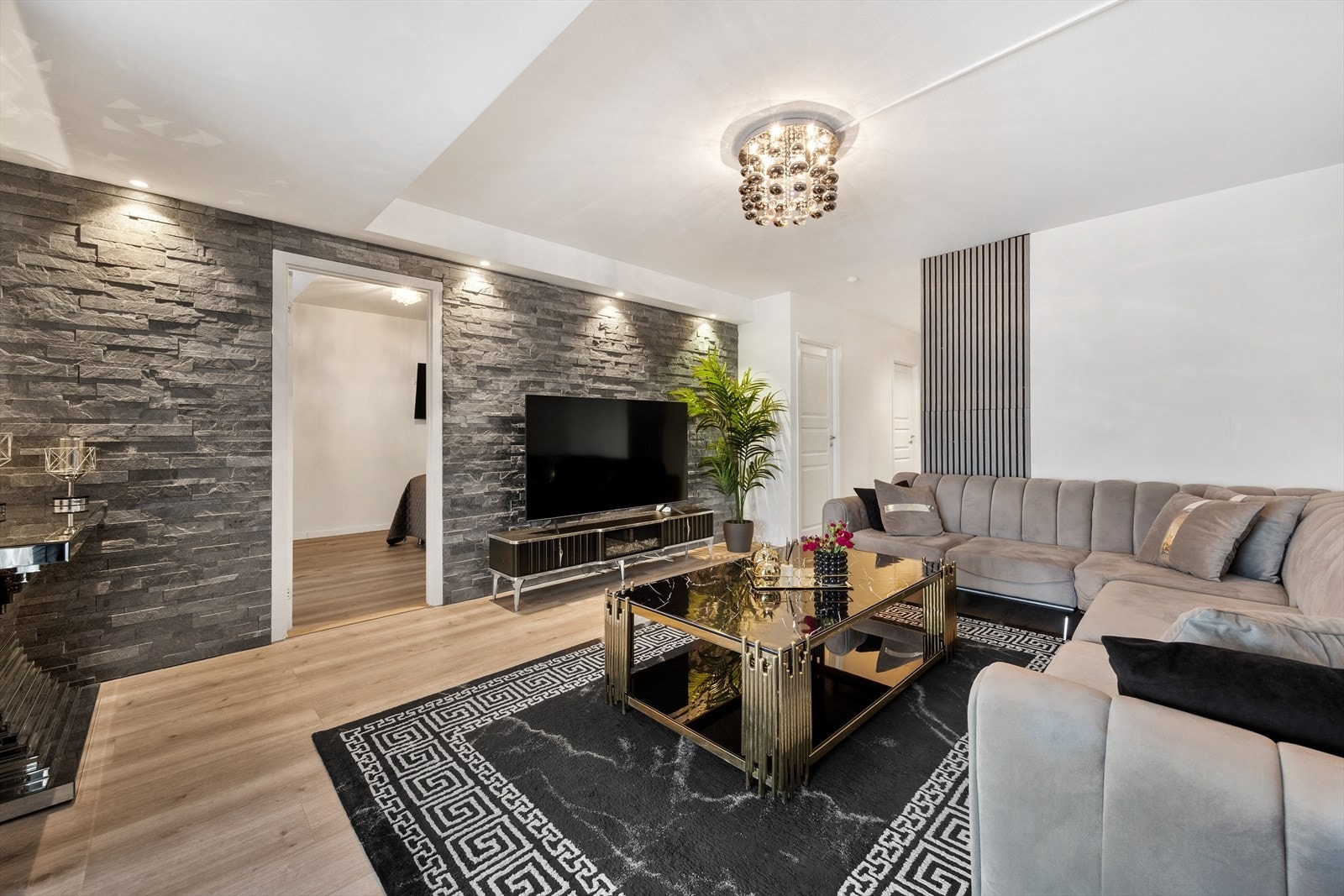 En vegg med dekorstein gir stuen et særpreg og definerer sonen for TV og media. Galleribilde