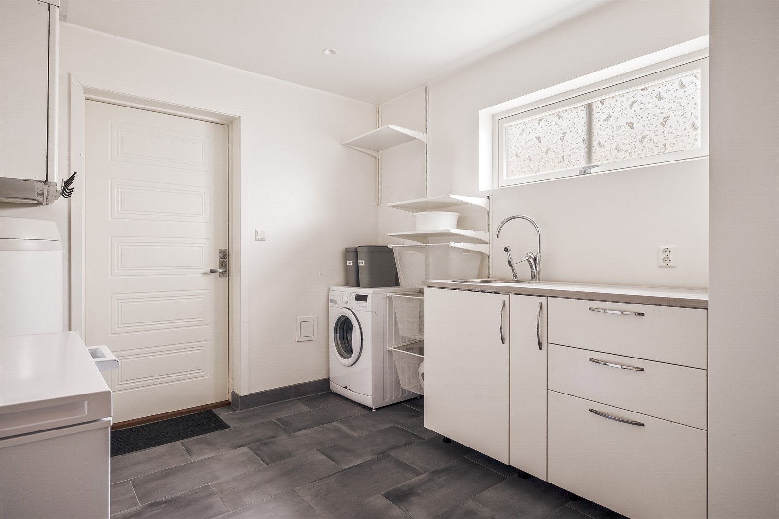 Vaskerommet måler et areal på 11,7 m² og er godt utstyrt med god benkeplass og skapplass. Praktisk med egen inngang! Galleribilde