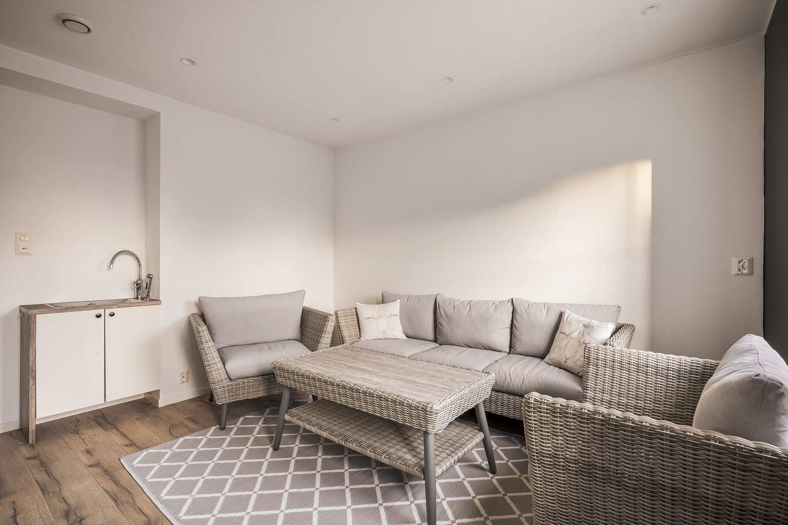 Her er det installert et lite benkeskap med vask, kjøkkenarmatur og hånddusj Galleribilde