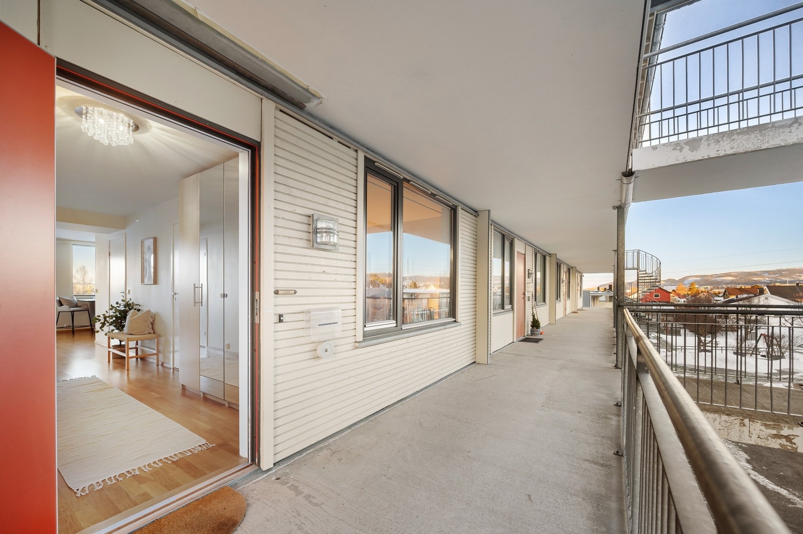 Svalgangen utenfor leiligheten, hvor leiligheten som selges ligger helt i enden av denne svalgangen. Her er det også mulig å nyte morgensolen - ved å ha f.eks. et kafésett utenfor inngangsdøra. Galleribilde