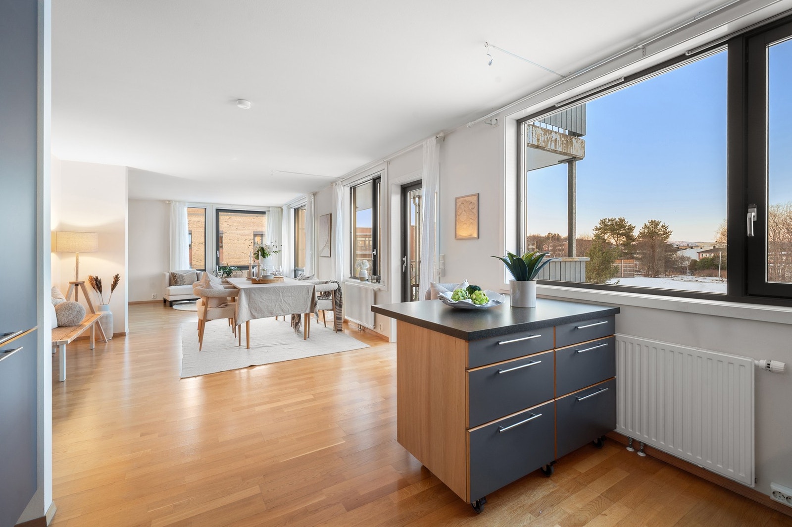 Kjøkken sett mot spisestua og videre mot stua. Det er god plass og avstand mellom spisestuedelen og kjøkkenet. Store og fine vinduer er også plassert ved siden av kjøkkenet. Galleribilde