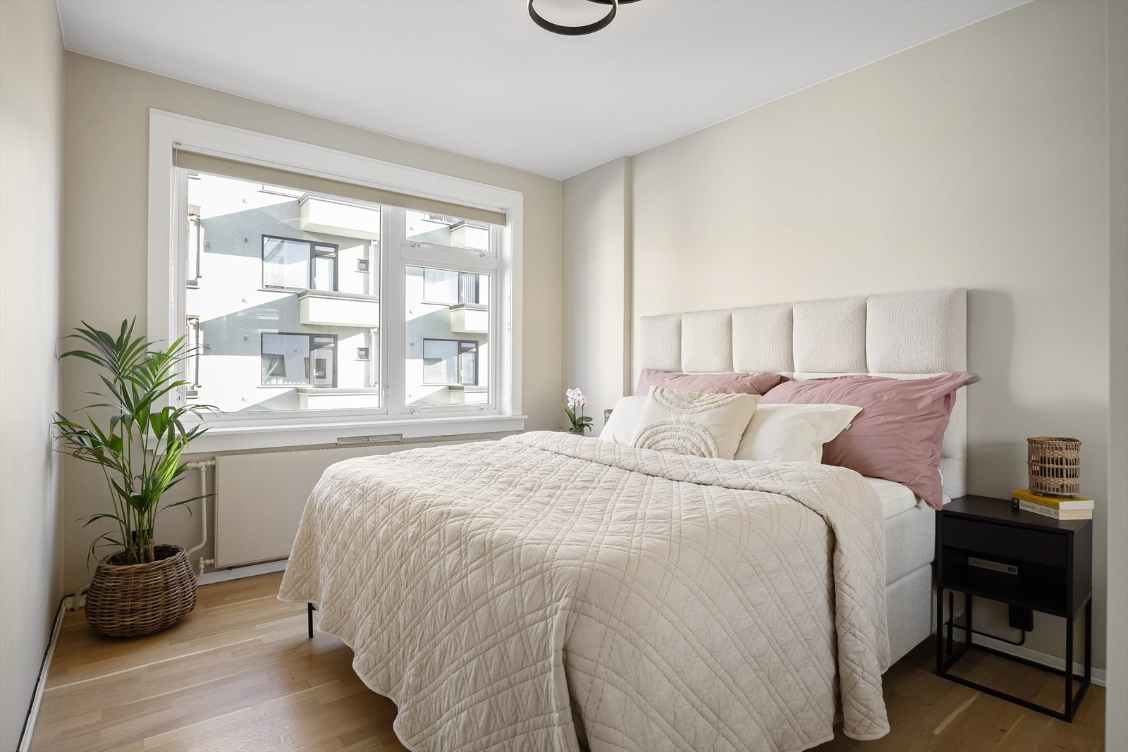 Lyst og romslig soverom med god plass til en stor dobbeltseng og nattbord på begge sider Galleribilde