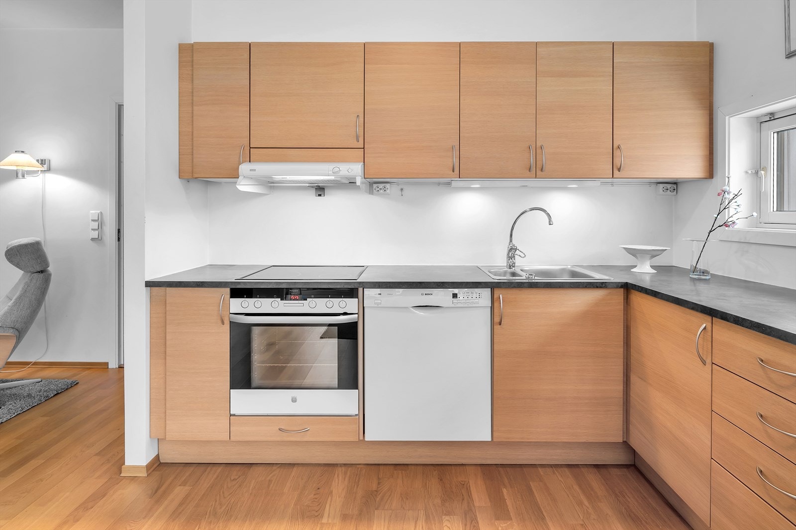 Pent kjøkken med slette fronter og laminatbenkeplate. God plass til oppbevaring i både skuffer og skap gjør kjøkkenet både funksjonelt og praktisk. Galleribilde