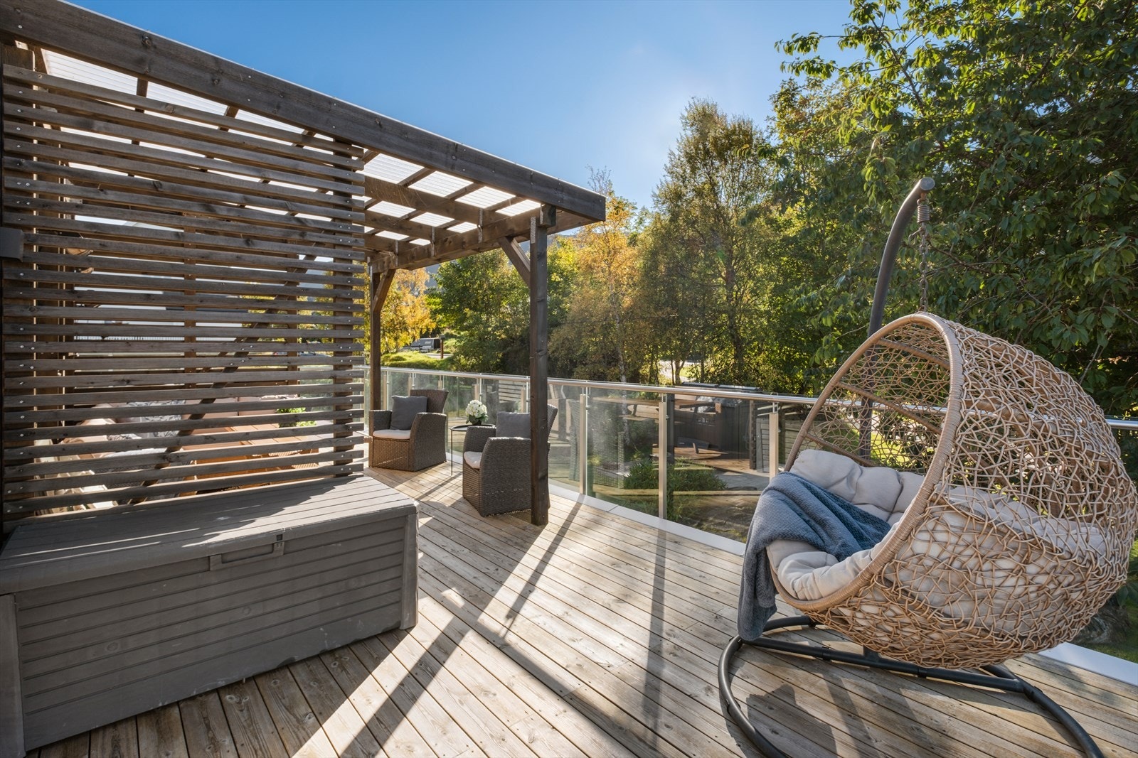 Glassrekkverket på verandaen gir et åpent utsyn mot det omkringliggende området. Galleribilde