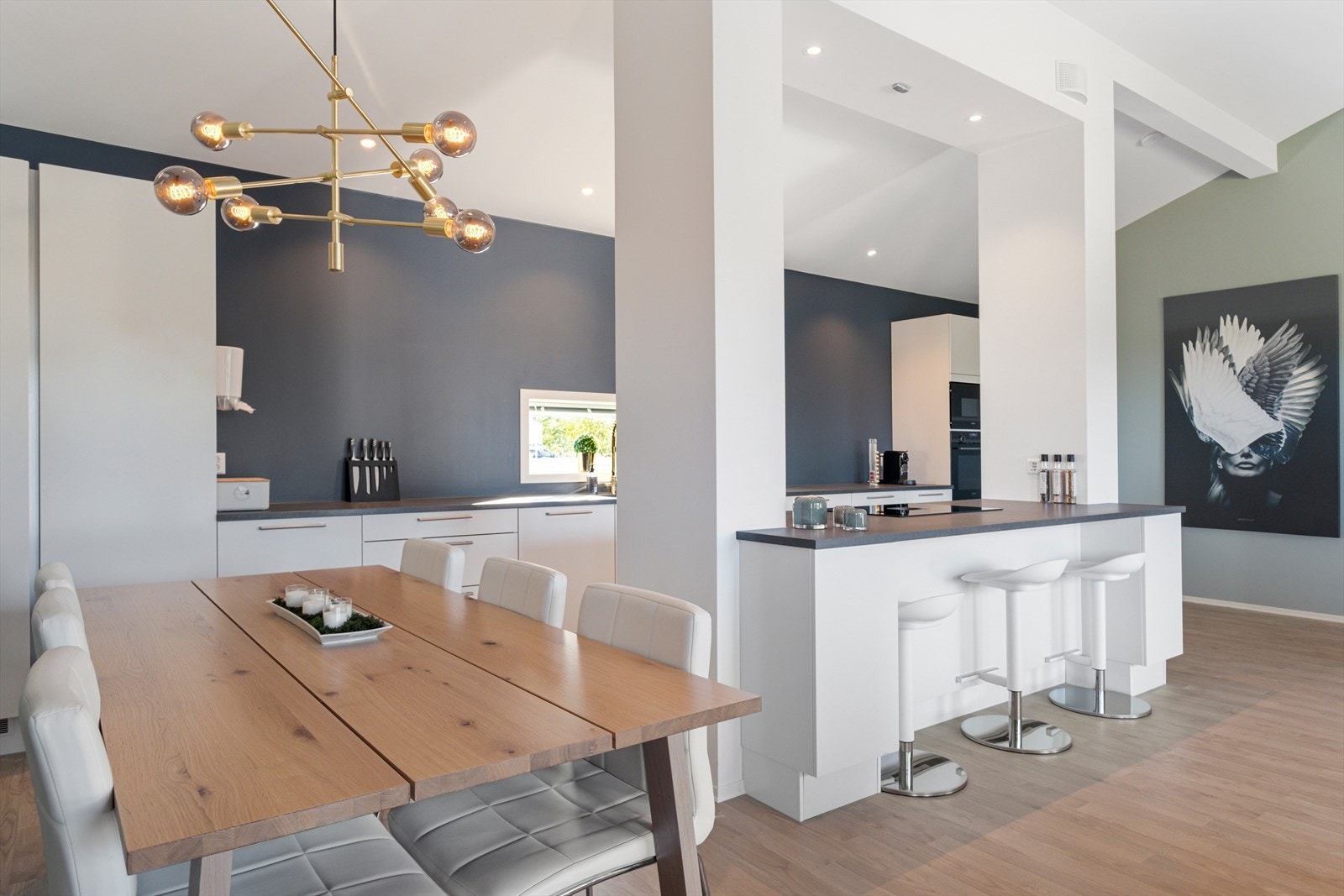 Eksklusivt kjøkkenmiljø med kjøkkenøy, barstoler og naturlig plass for sosiale sammenkomster. Galleribilde