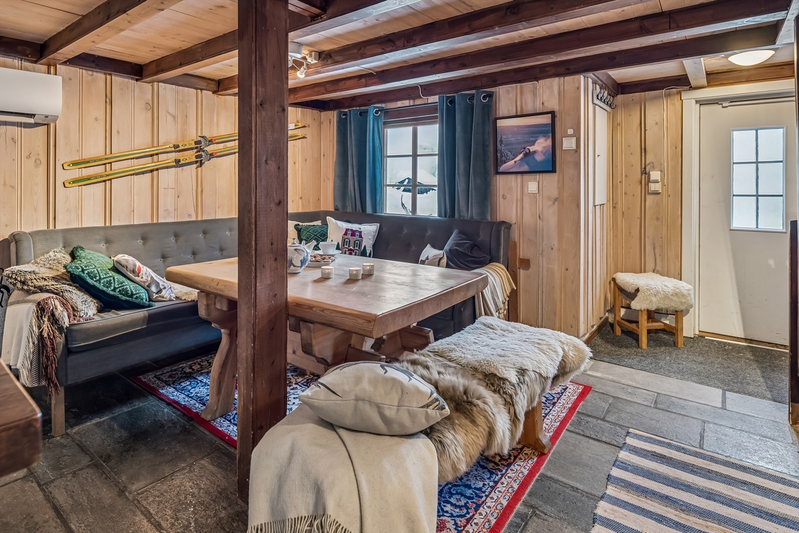 Slitesterkt skifergulv og gjennomgående trepaneler skaper en autentisk og varig hytteatmosfære. Galleribilde