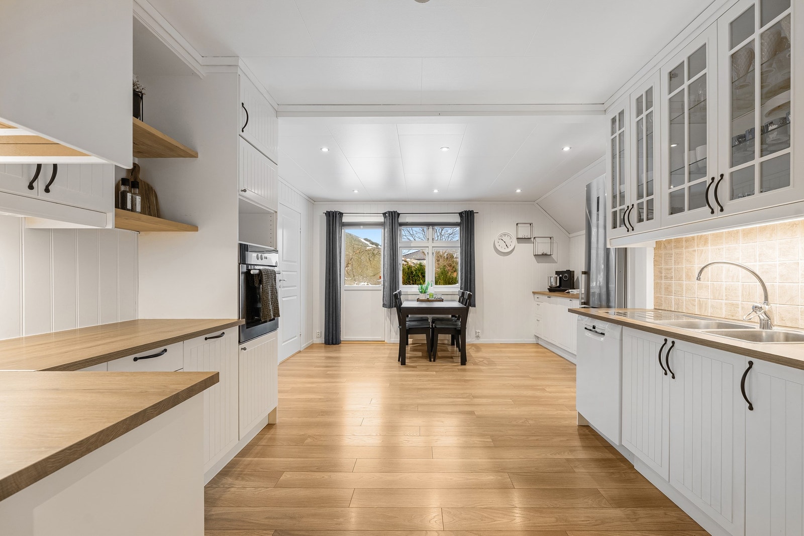 Stort kjøkken med mye oppbevaring og benkplass. Galleribilde